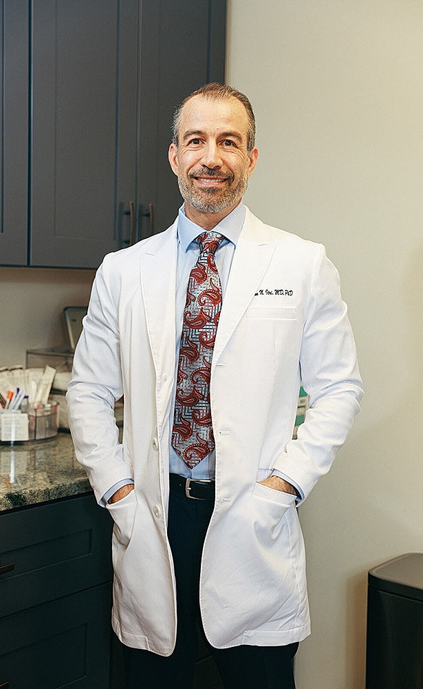 Doctor in white coat smiling in office setting